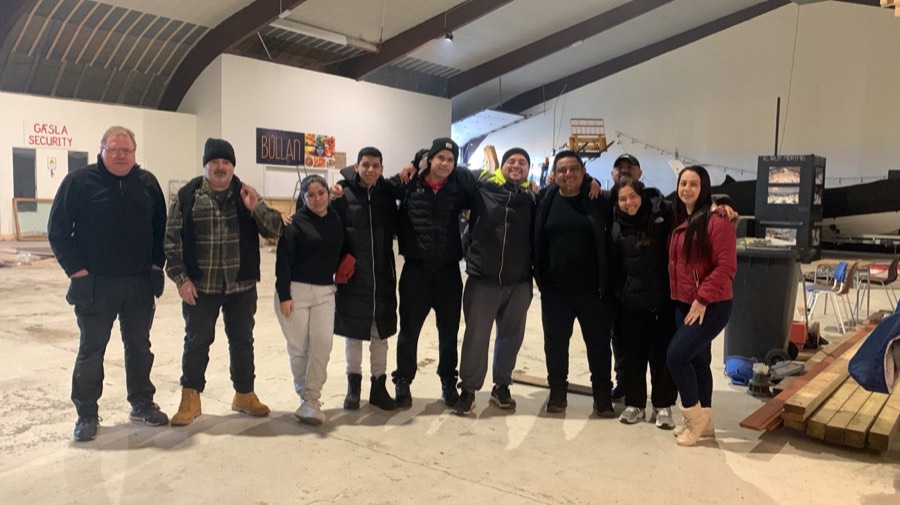 Voluntarios abrazados dentro de una bodega